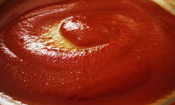 Reducing tomato sauce into paste in a wide pan